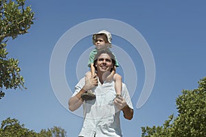 Farther Carrying Son On Shoulders Outdoors