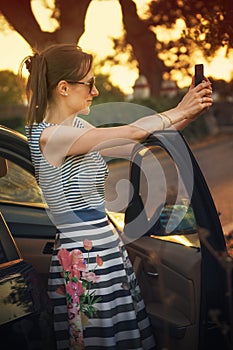 Faschion girl takes a selfie with her smartphone