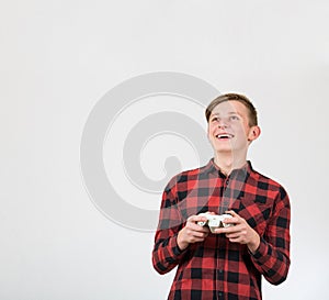 Fascinated teen boy playing video games isolated over white background. Excited adolescent stand all ears holding a joystick