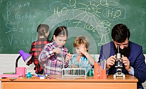 Fascinating chemistry lesson. Man bearded teacher and pupils with test tubes in classroom. Observe reaction. Science is