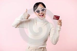 Fascinating fun joyful young woman of Asian ethnicity 20s years old with wear sunglasses wears white shirt hold in hand credit