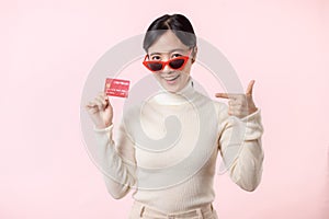 Fascinating fun joyful young woman of Asian ethnicity 20s years old with wear sunglasses wears white shirt hold in hand credit