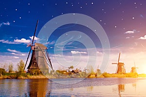 Fascinating scenic picture of windmills in Kinderdijk, Netherlands, Europe against the sky at the stars at dawn.