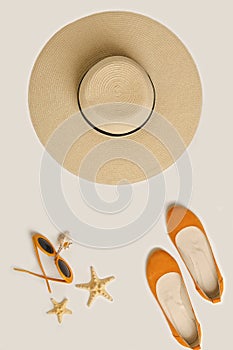 Fashion accessories for the beach - hat, ballet shoes, orange glasses on a white background.