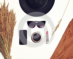 Fashion accessory, female black round hat, sunglasses, screen phone, pocket mirror, red lipstick with dry spikelets plants