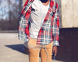 Fashion african man in red plaid shirt listens to music