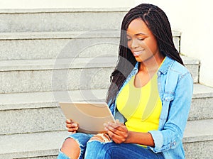 Fashion african woman using tablet pc computer sitting