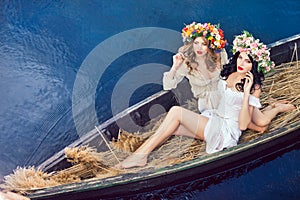 Fashion art photo of a beautiful girls in boat