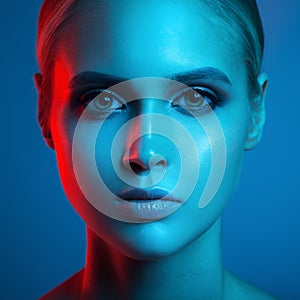 Fashion art portrait of beautiful woman face. Red and blue light