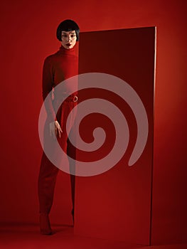 Fashion, art and portrait of woman with red board, futuristic makeup and unique studio background. Future aesthetic