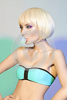 Fashion art portrait of a woman in a swimsuit with bright contrasting makeup. Creative beauty photo of a girl on a contrasting