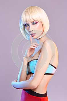 Fashion art portrait of a woman in a swimsuit with bright contrasting makeup. Creative beauty photo of a girl on a contrasting