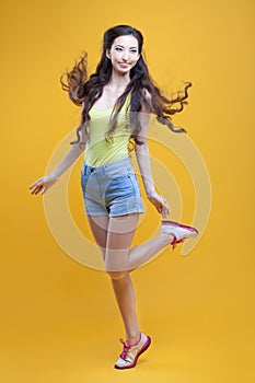 Fashion asian young girl. Portrait on yellow