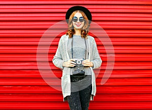 Fashion autumn portrait smiling woman holds retro camera