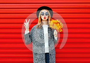 Fashion autumn young woman with red lips and yellow maple leaves