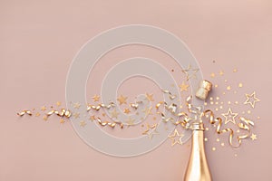 Fashion background with golden champagne bottle, confetti stars, holiday decoration and party streamers. Christmas card