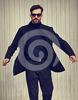 Fashion beard style business handsome male model in fashion sunglasses with serious concentrated look whirling and moving in style
