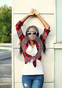 Fashion beautiful african woman wearing a red checkered shirt and sunglasses