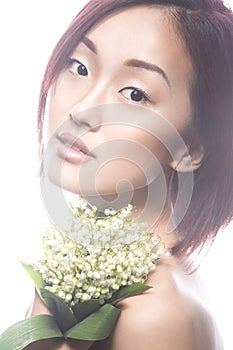 Fashion beautiful girl oriental type with delicate natural make-up and flowers. Beauty face.