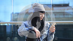 Fashion beautiful hispanic latina woman texting on smartphone in the city.