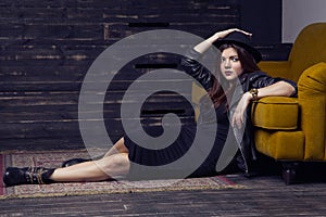 Fashion beautiful middle eastern model with hipster style is posing on carpet and yellow sofa.