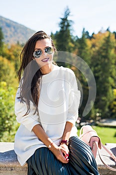 Fashion beautiful woman portrait wearing sunglasses, white sweater and green skirt