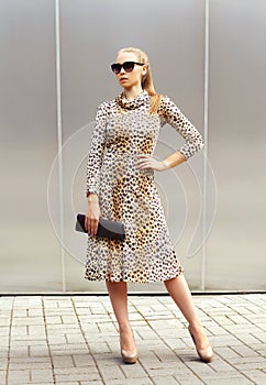 Fashion beautiful woman wearing a leopard dress and sunglasses