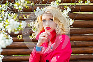 Fashion beauty blonde model girl. Beautiful spring girl in blooming tree Flowers. Perfect Creative Make up and Hair