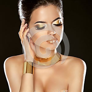 Fashion Beauty Girl Isolated on Black Background. Golden Jewelry