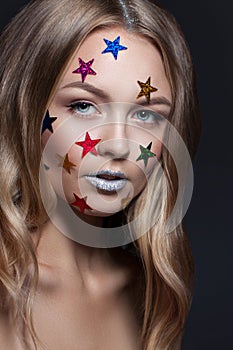 Fashion beauty glamor girl. Multi-colored metallic stars in her hair.