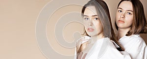 Fashion beauty models two sisters twins beautiful nude girls isolated on beige background, banner