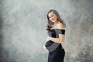 Fashion beauty portrait of beautiful pregnant woman on gray background
