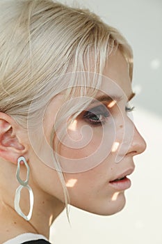 Fashion beauty portrait of young beautiful woman wearing earrings