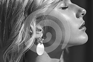 Fashion beauty portrait of young beautiful woman wearing earrings. Black and white