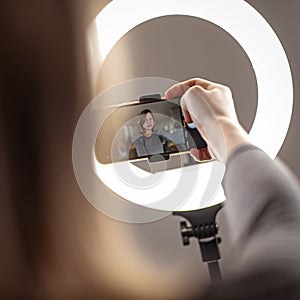 Fashion blogger girl making a video with a ring light