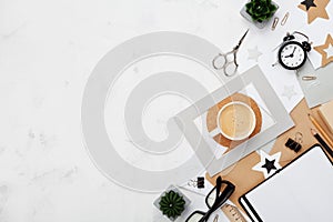 Fashion blogger workspace background. Coffee, office supply, alarm and clean notebook on white desk top view. Flat lay style.