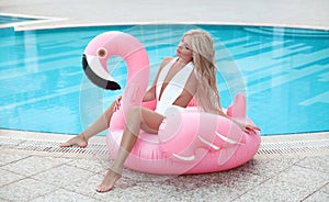 Fashion blond model woman in white bikini posing on Pink in