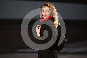 Fashion blond woman walking on night city street