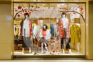 Fashion boutique displaying window with mannequins