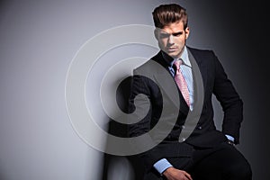 Fashion business man in suit and tie is sitting