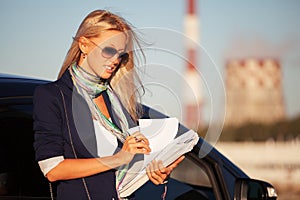 Fashion business woman with financial papers next to her car