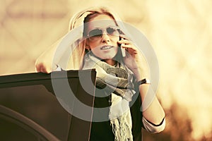 Fashion business woman in sunglasses calling on cell phone