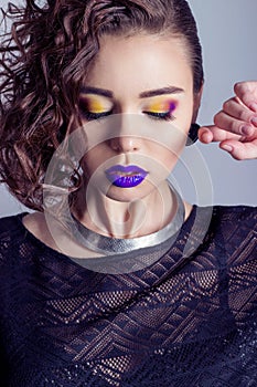 Fashion capture beautiful girl with bright makeup, big full lips with purple lipstick, beautiful hair. Photography makeup