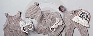 Fashion children's clothing, shoes. Set of knitted baby clothes. Newborn beige romper, hat, jumper, pants, boots on