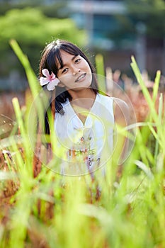 Fashion close-up portrait of young Asian woman posing at grassplot