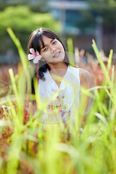 Fashion close-up portrait of young Asian woman posing at grassplot photo