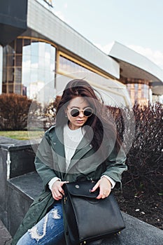 Fashion closeup portrait of nice pretty young hipster woman posing in sunglasses Outdoor .Brunette happy girl in green