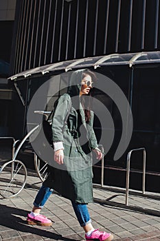 Fashion closeup portrait of nice pretty young hipster woman posing in sunglasses Outdoor .Brunette happy girl in green