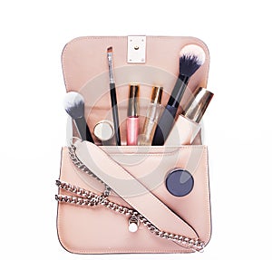 Fashion concept : Flat lay of pink leather woman bag open out with cosmetics and accessories on white background.