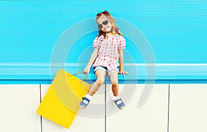 Fashion cool kid with shopping bag on colorful blue background